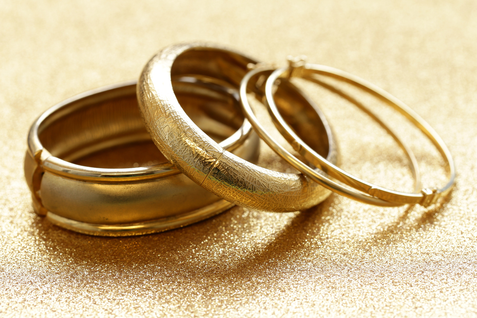 gold jewelry bracelets on gold background