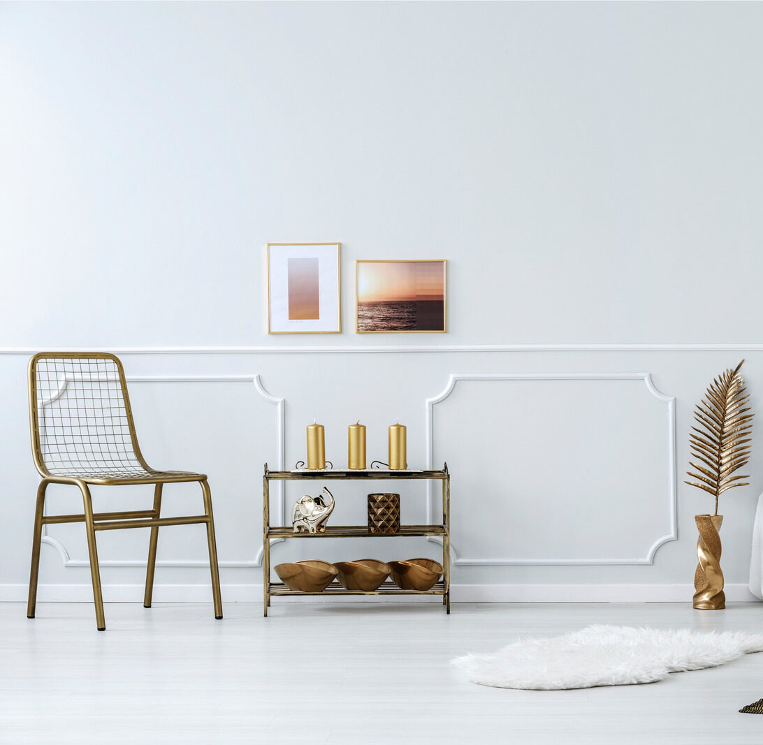 Gold accents in bedroom interior with bed, chair, metal shelf and modern lamp