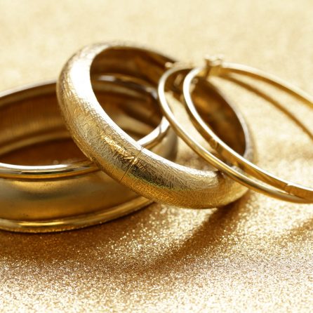 gold jewelry bracelets on gold background